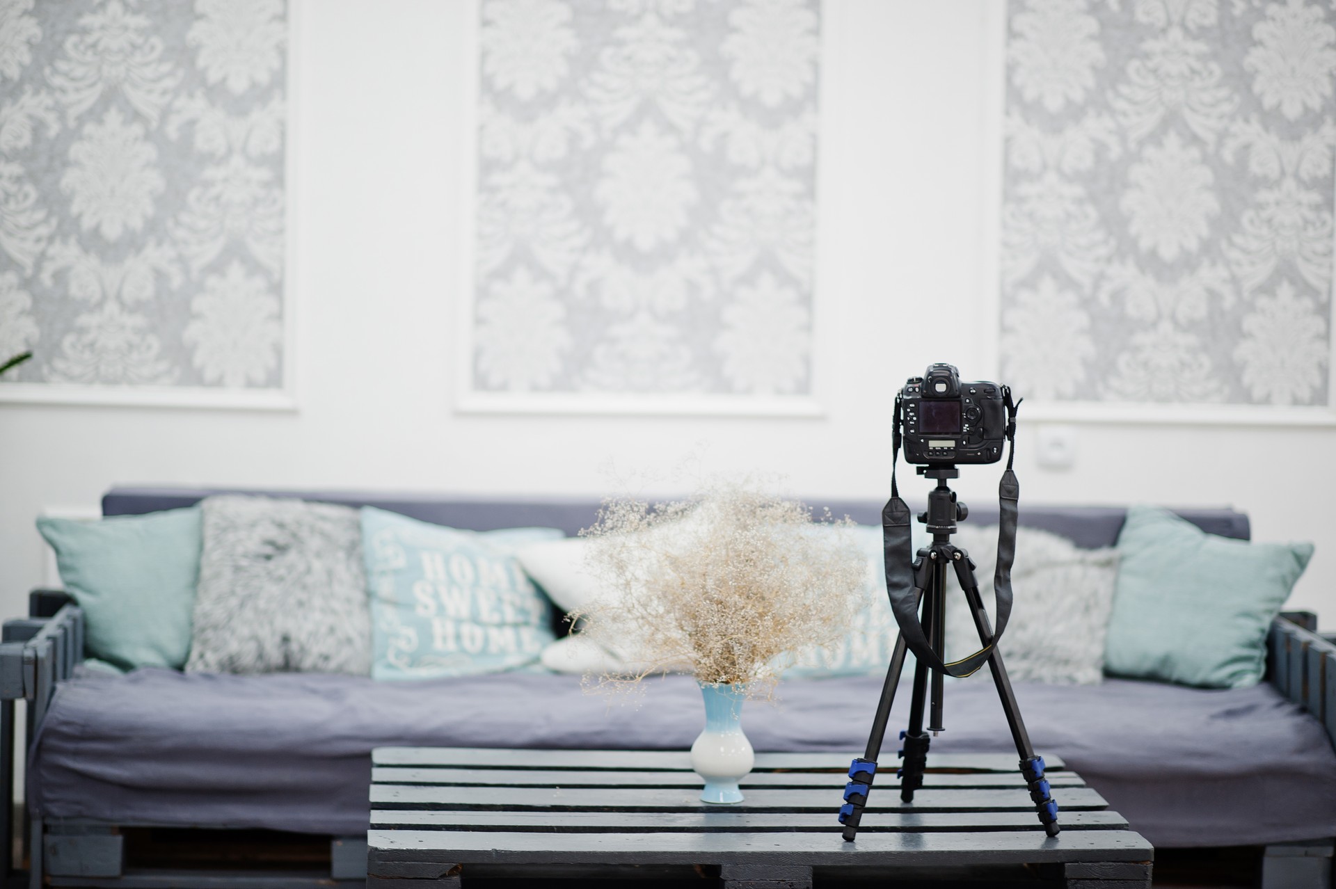 Camera on a tripod in cozy bedroom interior.